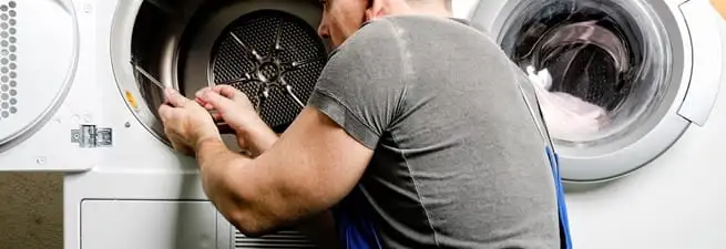 Dryer repair technician fixing a clothes dryer drum in Staten Island, NY