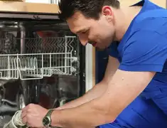 Dishwasher repair technician inspecting and servicing an open dishwasher in Staten Island, NY