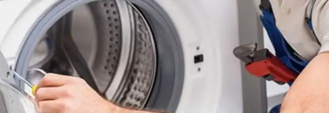 Appliance technician repairing a clothes dryer drum and internal parts in Staten Island, NY