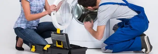 Washer repair technician inspecting a front-load washing machine with tools in Staten Island, NY