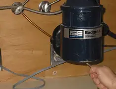 Garbage disposal repair technician tightening the mounting ring under a sink in Staten Island, NY