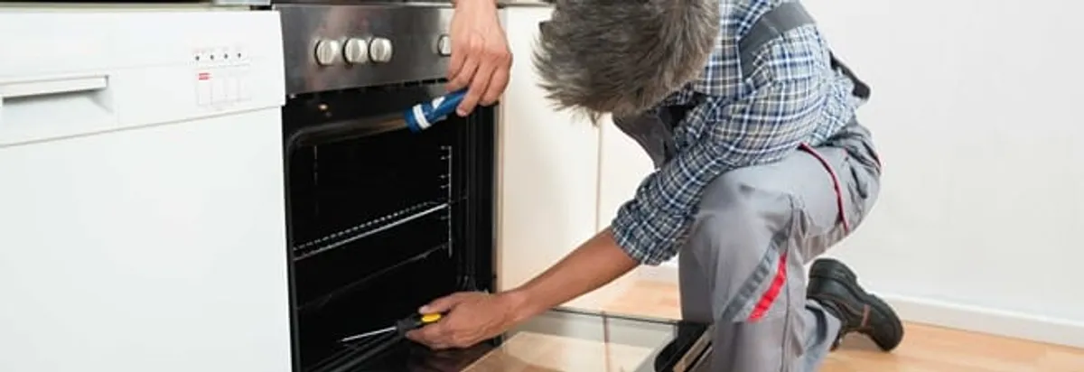 Oven repair technician inspecting and servicing an electric oven in Staten Island, NY