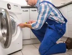 Washing machine repair technician servicing a front-load washer in Staten Island, NY