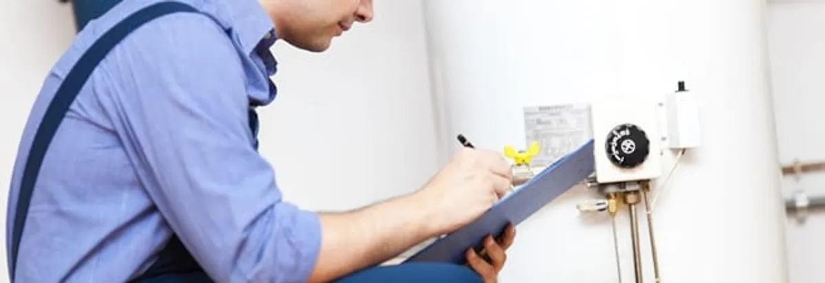 Water heater repair technician inspecting the unit and recording service notes in Staten Island, NY